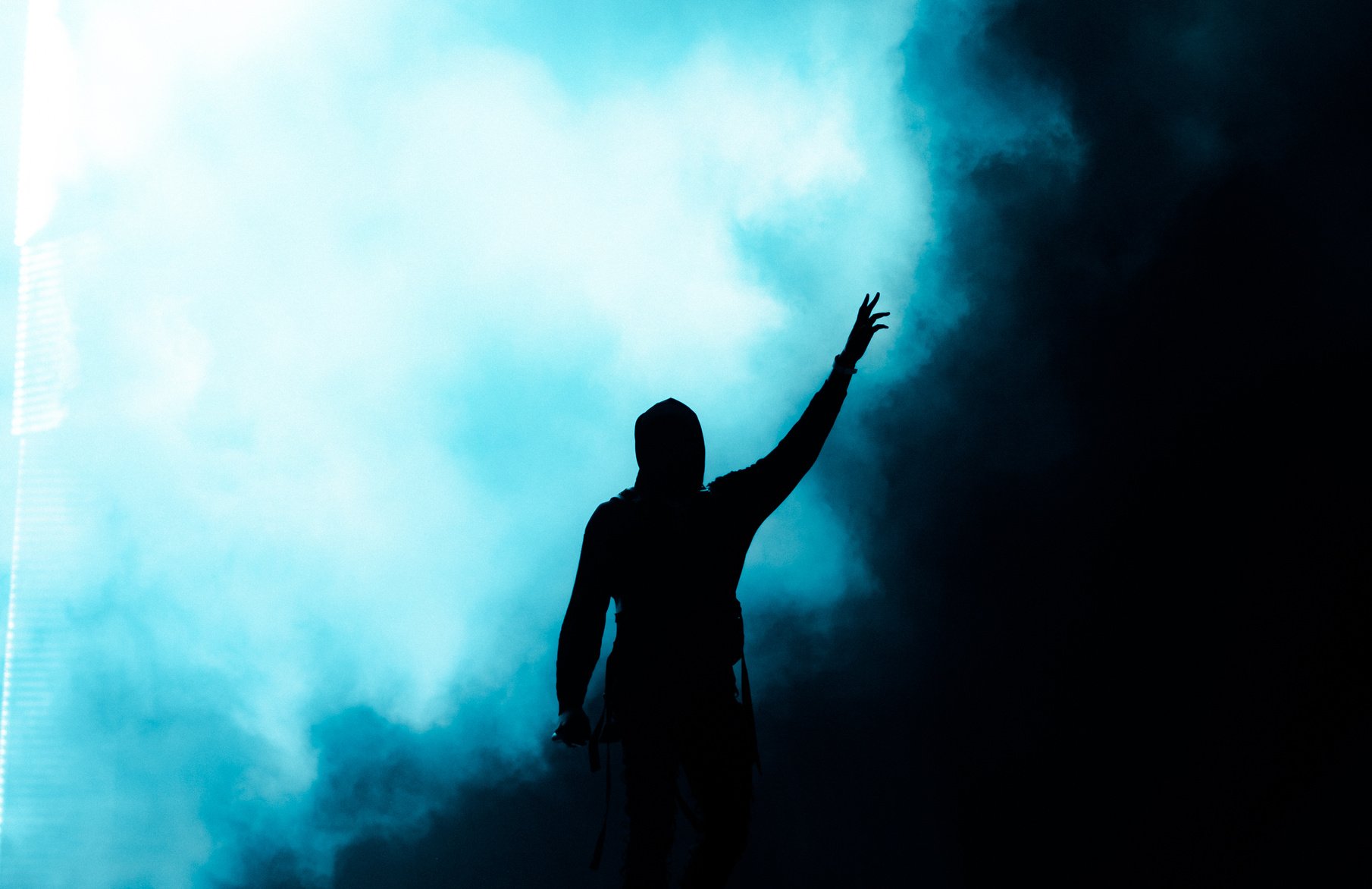 Dark silhouette with hand reaching up for light in smoke